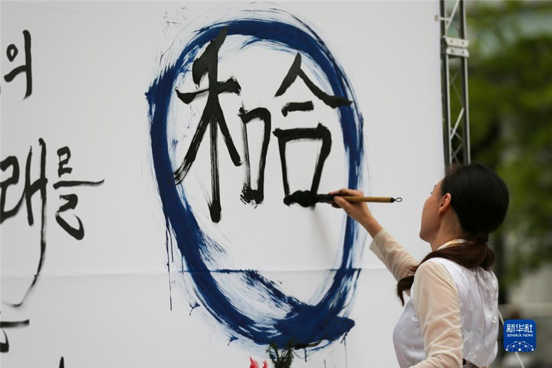 5月30日，在韓國首爾舉辦的“中日韓合作之日”慶?；顒又?，表演者進行中日韓精神——2023年度漢字“和合”書法表演。新華社記者 王益亮 攝