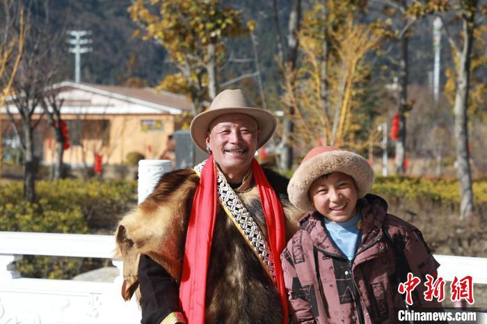圖為林芝市巴宜區(qū)布久鄉(xiāng)仲果村村民桑杰與孫子一起參加藏歷新年活動。　張力 攝